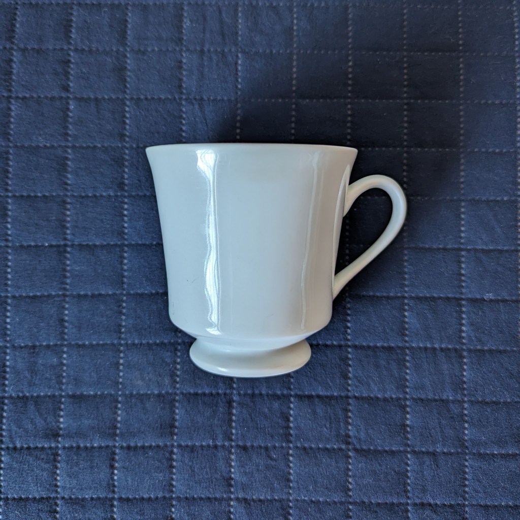 Xícara branca sobre fundo azul escuro